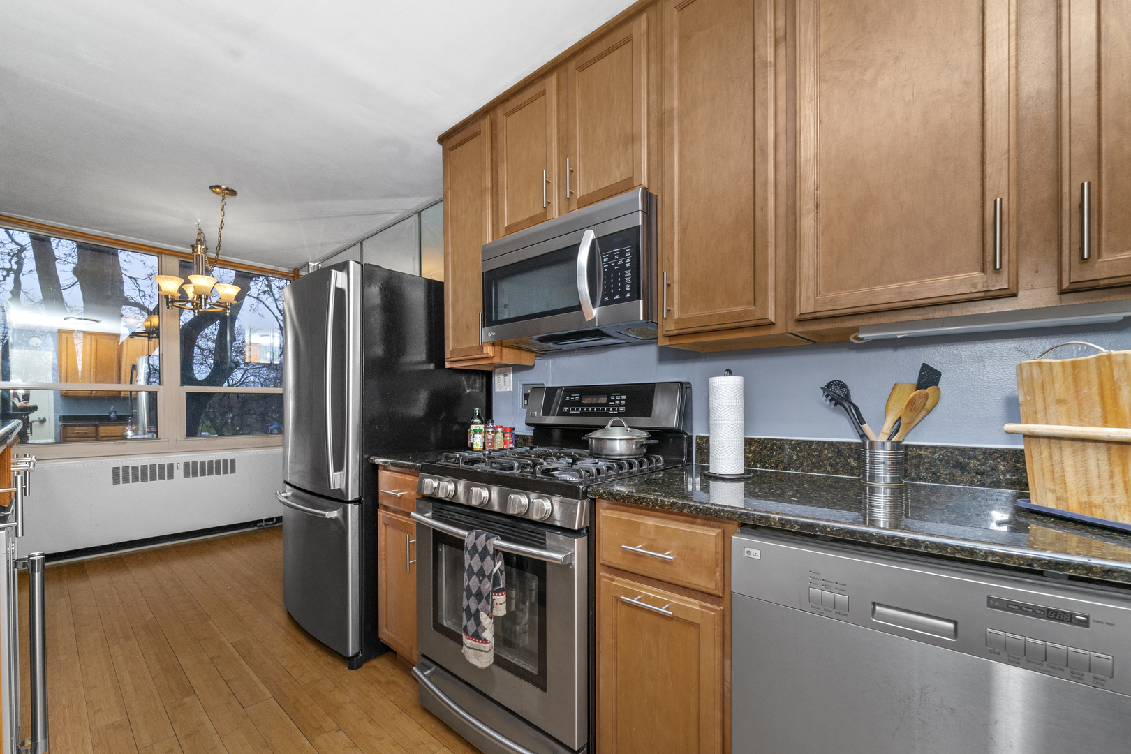3950 North Lake Shore Drive, Unit 228 Chicago, IL 60613 - Photo 8 of 28 a kitchen with stainless steel appliances granite countertop a stove a sink and a microwave