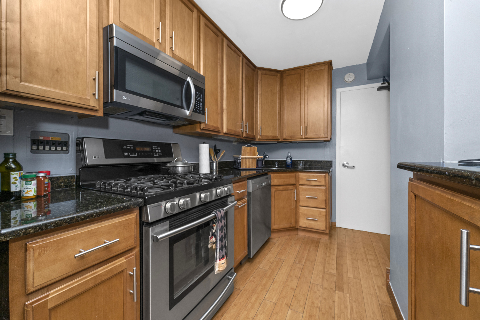3950 North Lake Shore Drive, Unit 228 Chicago, IL 60613 - Photo 9 of 28 a kitchen with stainless steel appliances granite countertop a stove a sink and a microwave
