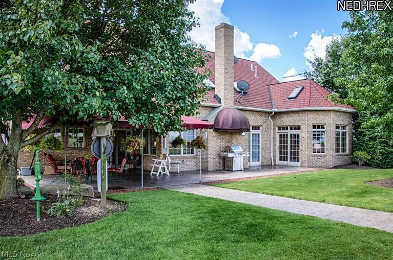 14360 Butternut Road Burton, OH 44021 - Photo 2 of 25 Large stamped patio and sidewalks with an elegant covered sitting area and a fluted cover over the grill to keep you away from sunrays.