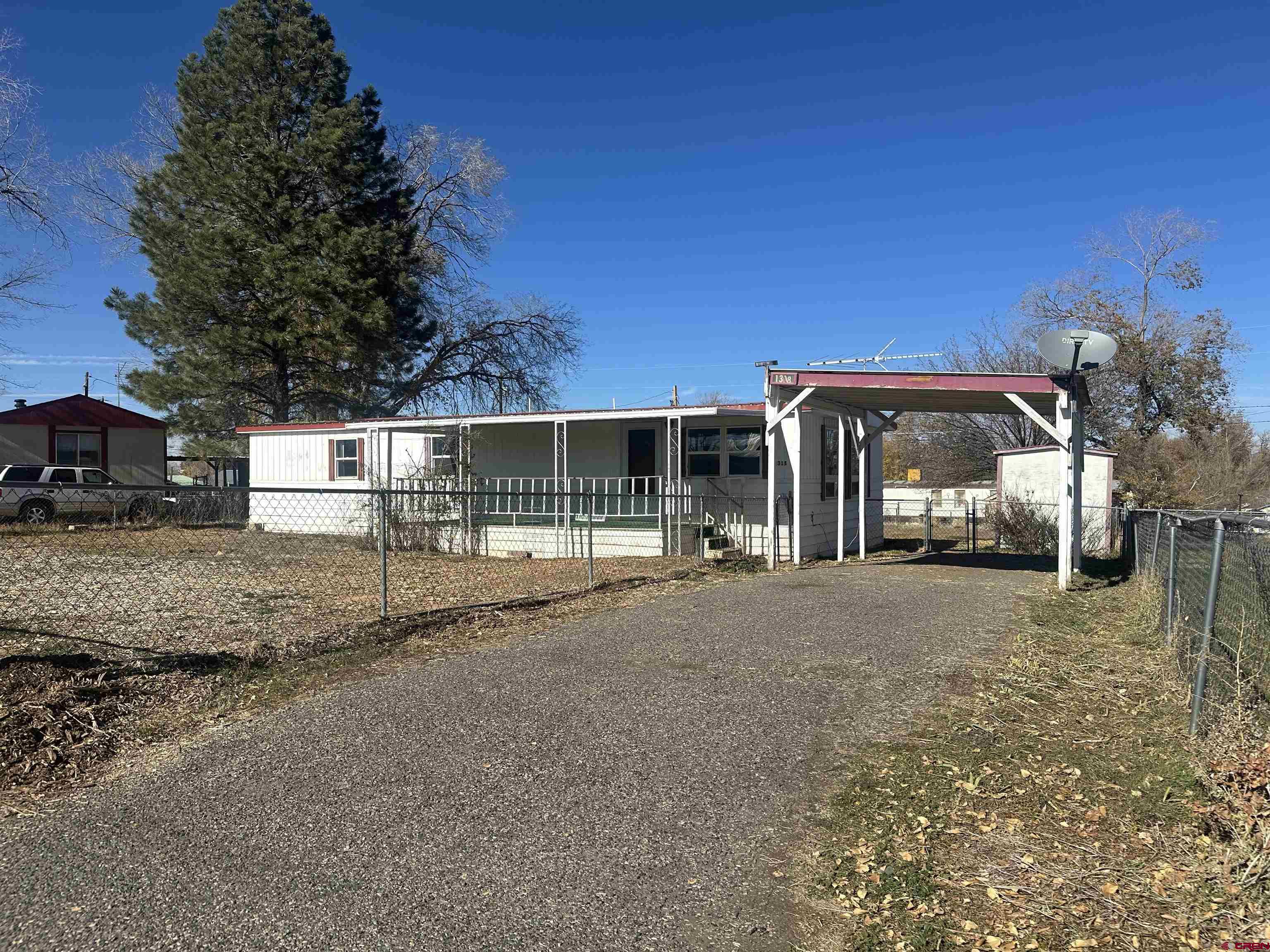 a view of a house with a backyard and tree