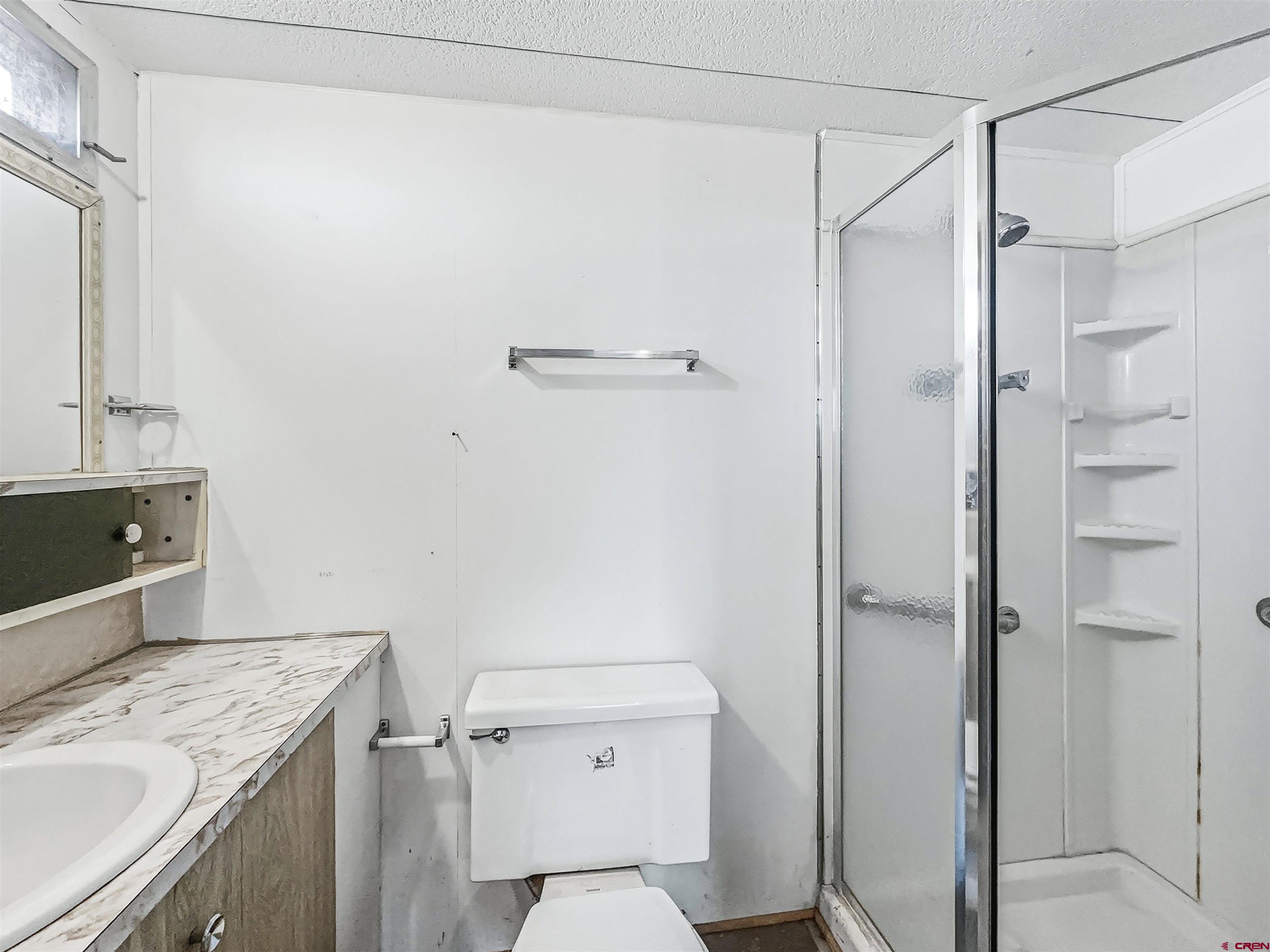 1318 Jackson Street Cortez, CO 81321 - Photo 12 of 13 a bathroom with a granite countertop sink toilet and shower