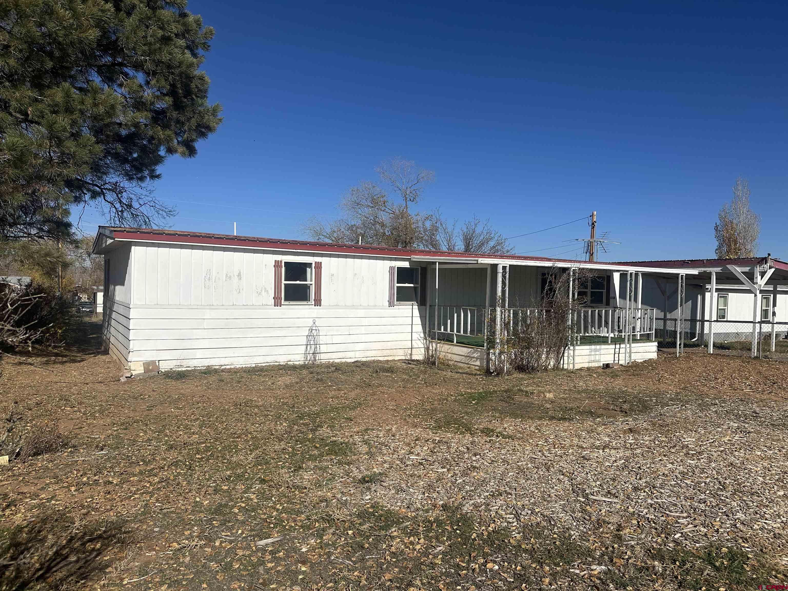 1318 Jackson Street Cortez, CO 81321 - Photo 3 of 13 a front view of a house with garden