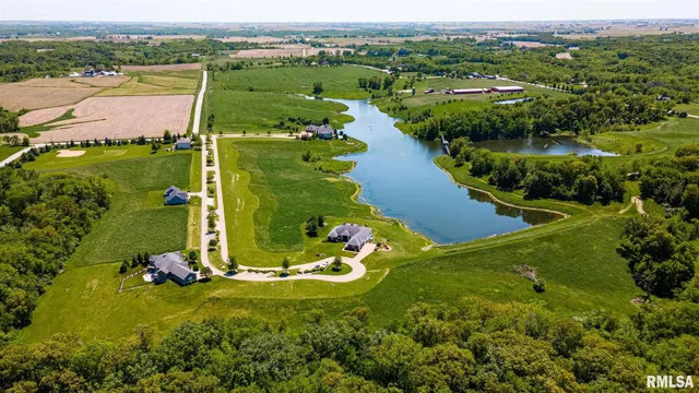 an aerial view of a house with a garden and lake view