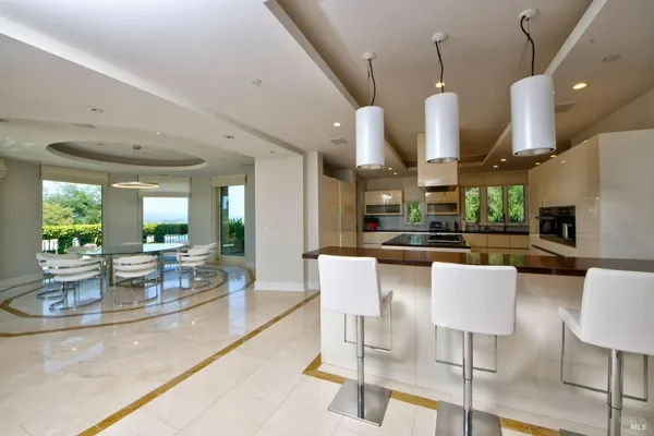a kitchen with stainless steel appliances kitchen island granite countertop a table and chairs in it
