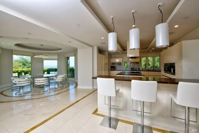 a kitchen with stainless steel appliances kitchen island granite countertop a table and chairs in it