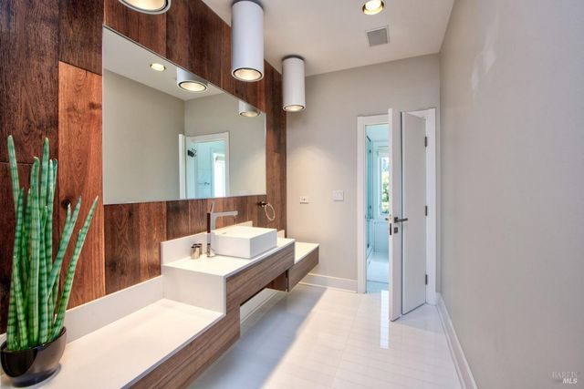 a bathroom with a tub sink and mirror