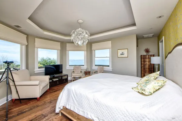 a spacious bedroom with a bed and wooden floor