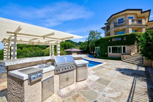 a view of a swimming pool with lawn chairs under an umbrella