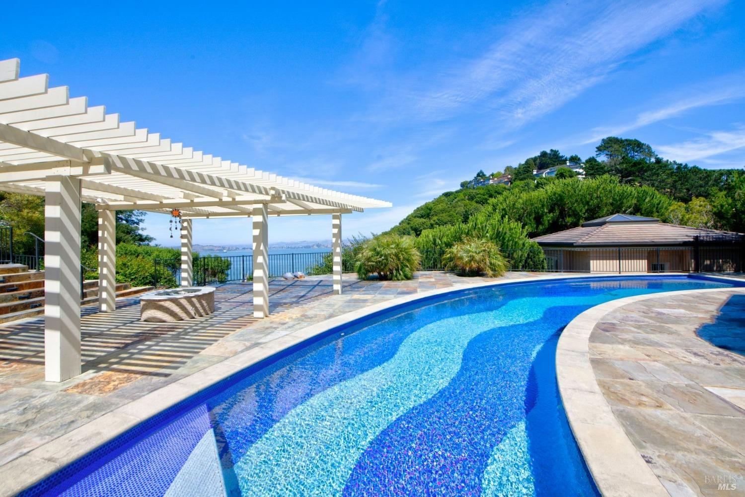185 Gilmartin Drive Tiburon, CA 94920 - Photo 32 of 32 a view of a swimming pool with lawn chairs under an umbrella