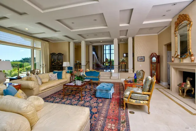 a living room with furniture fireplace and a large window