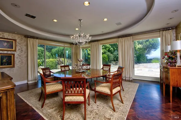 a dining room with furniture a chandelier and wooden floor