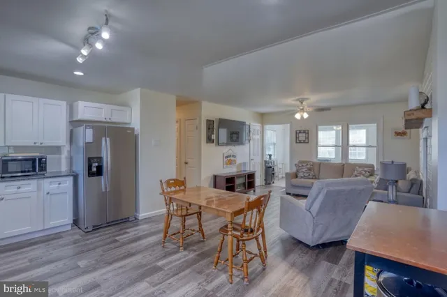 a living room with furniture wooden floor and a kitchen view