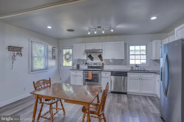 a kitchen with a table chairs refrigerator and cabinets