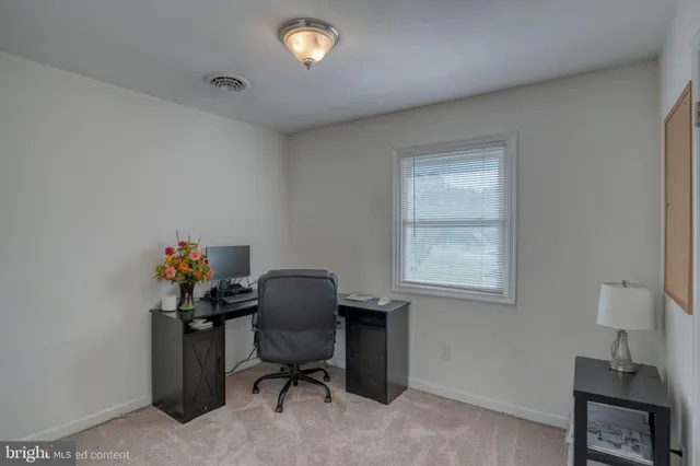 a view of a workspace with furniture and a window