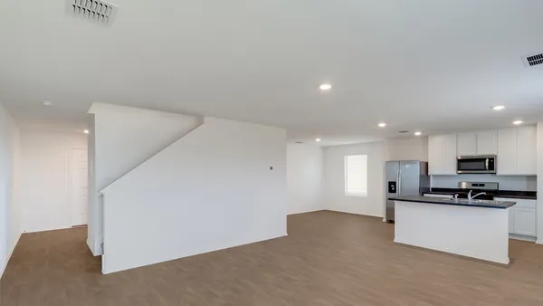 a view of kitchen with kitchen island white cabinets and stainless steel appliances