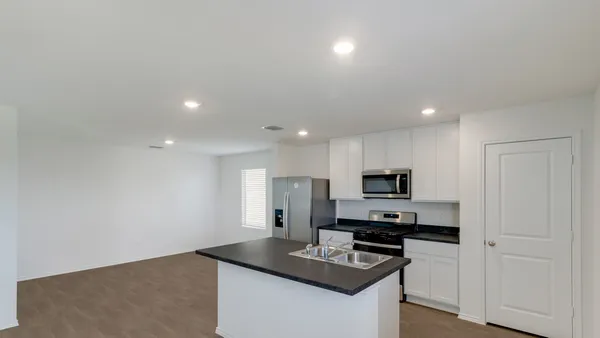 a kitchen with granite countertop a stove and a sink