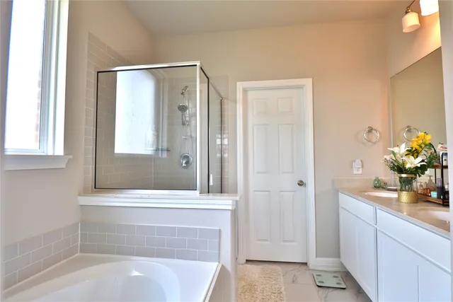 a spacious bathroom with a tub shower and sink