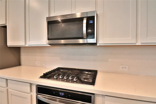 a kitchen with stainless steel appliances granite countertop a refrigerator a sink dishwasher and a stove with wooden floor