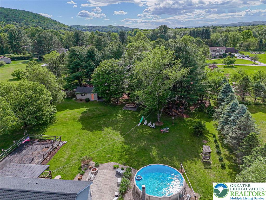 341 Lower Greenhill Road Kunkletown, PA 18058 - Photo 49 of 69 An aerial perspective reveals a serene backyard with a vibrant pool and surrounding lush greenery.