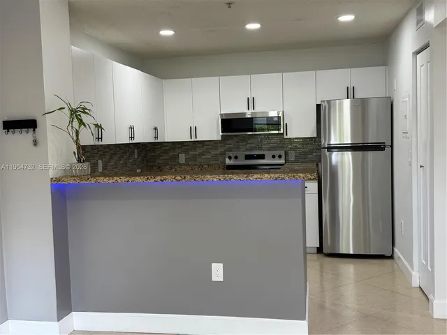 a kitchen with stainless steel appliances a refrigerator sink and microwave