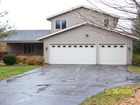 7663 East Rockton Road Roscoe, IL 61073 - Photo 1 of 10 a front view of a house with a yard and garage