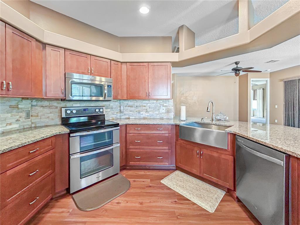 15598 Southwest 11th Terrace Road Ocala, FL 34473 - Photo 20 of 27 a kitchen with stainless steel appliances granite countertop a stove a sink and a microwave