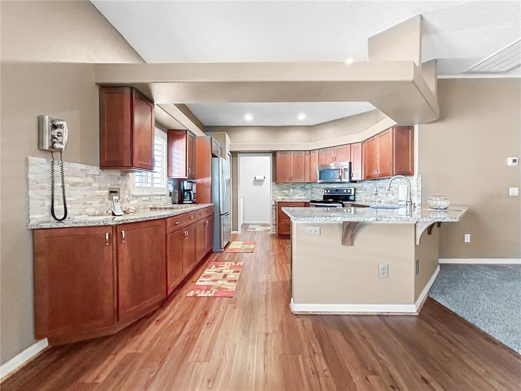 15598 Southwest 11th Terrace Road Ocala, FL 34473 - Photo 22 of 27 a kitchen with stainless steel appliances granite countertop a stove a sink dishwasher and a refrigerator