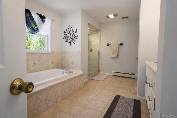 a bathroom with a tub a toilet and a shower