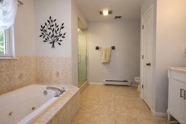 a bathroom with a tub sink and mirror
