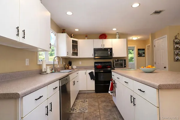 a kitchen with a sink a microwave a refrigerator and cabinets