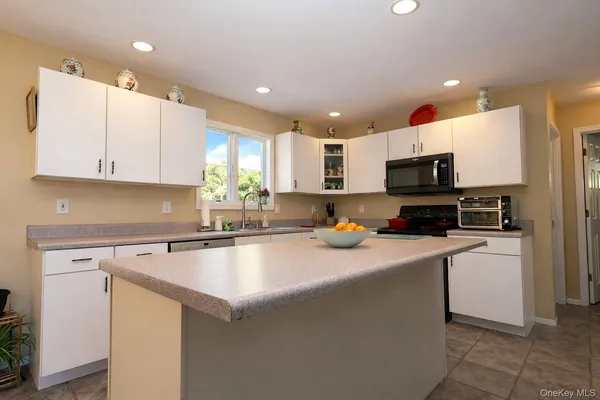 a kitchen with a sink a counter top space cabinets and stainless steel appliances