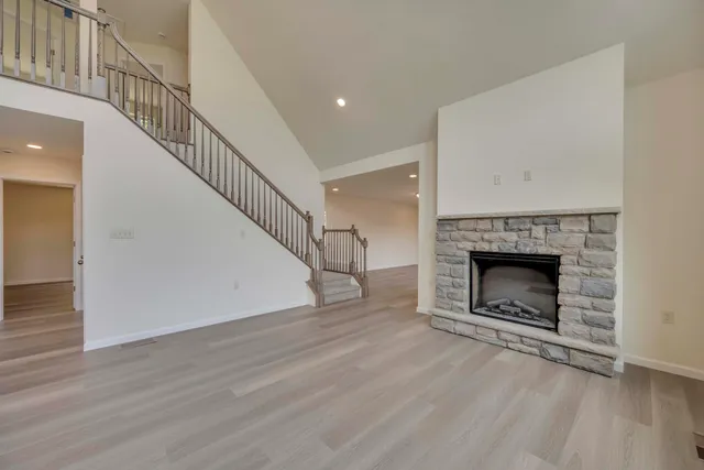 a view of a livingroom with wooden floor a fireplace and a window