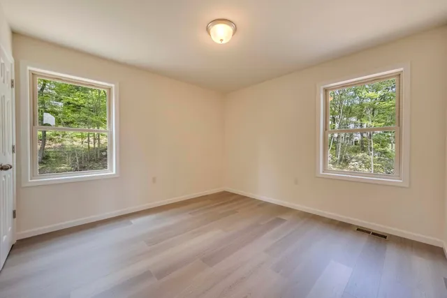 a view of a room with wooden floor and window