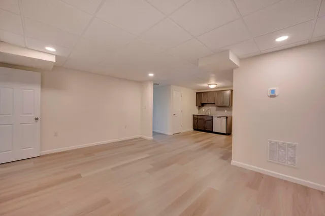 wooden floor in an empty room with a kitchen