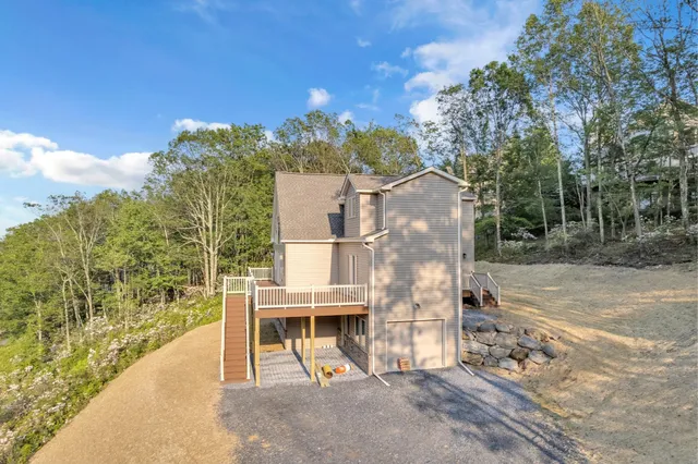 a view of a house with a yard and large tree