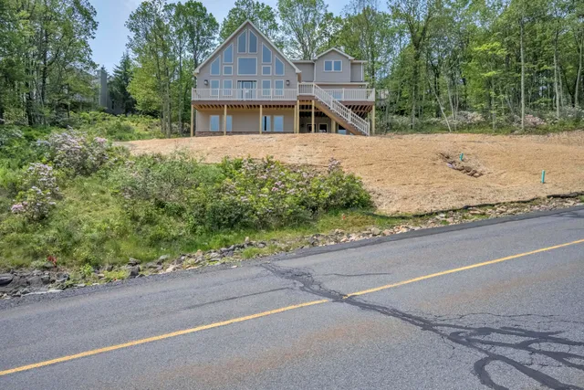 a view of a house with backyard and a tree