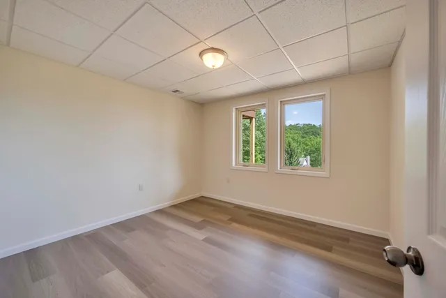 an empty room with wooden floor and windows