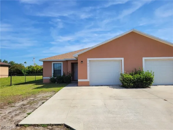 a front view of a house with a yard and garage