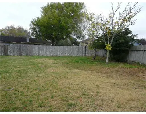 a view of a yard with wooden fence