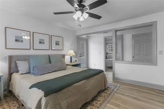 a bedroom with a large bed and a chandelier fan