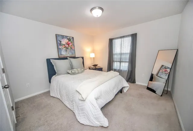 a spacious bedroom with a bed and a large window