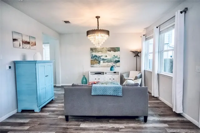 a living room with furniture wooden floor and a chandelier
