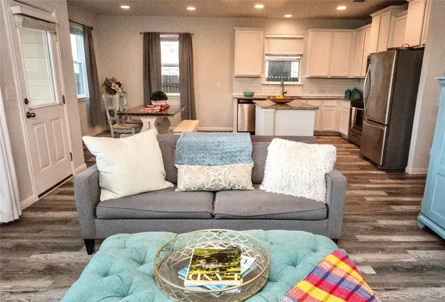 a living room with stainless steel appliances kitchen island granite countertop furniture and a view of kitchen