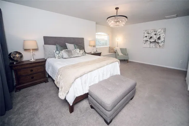 a bedroom with a bed and a chandelier