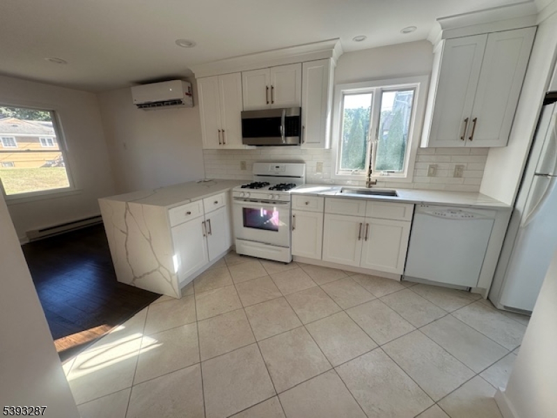 56 Buena Vista Road, Unit 1 Cedar Grove, NJ 07009 - Photo 3 of 16 a kitchen with a stove a sink and a refrigerator
