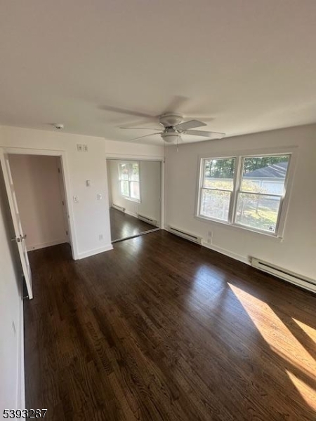 56 Buena Vista Road, Unit 1 Cedar Grove, NJ 07009 - Photo 6 of 16 an empty room with wooden floor and windows