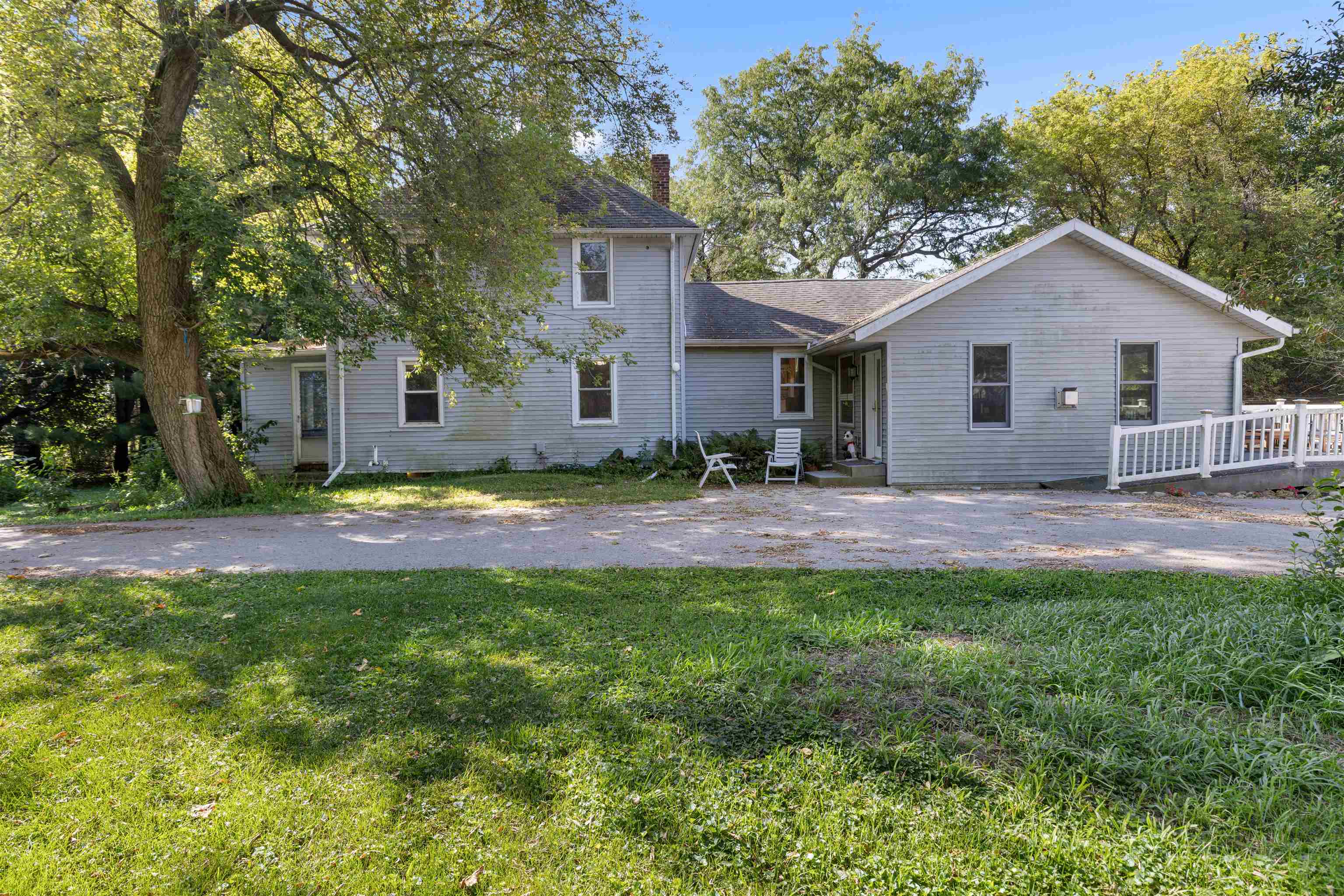 a view of a house with a yard and large tree