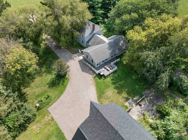 an aerial view of a house with a yard and trees