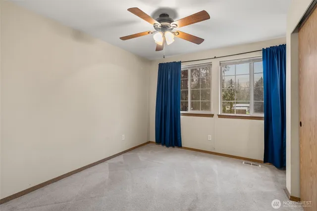 an empty room with a window and a fan