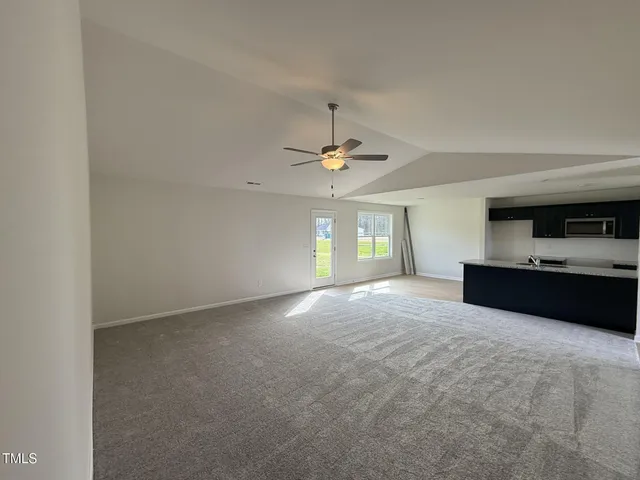 a view of an empty room with a kitchen